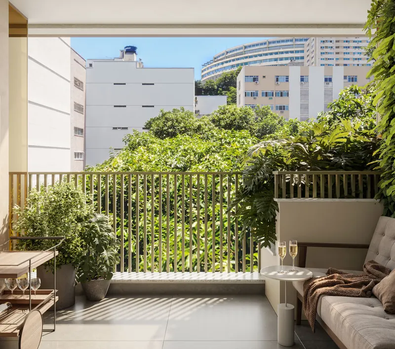 Varanda do apartamento 702 do Be in Rio Nascimento Silva 45, com sofá e jardineira voltada para o verde de Ipanema
